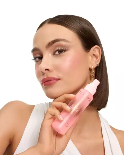 Woman with sleek bob holding Lancome Idole mist.